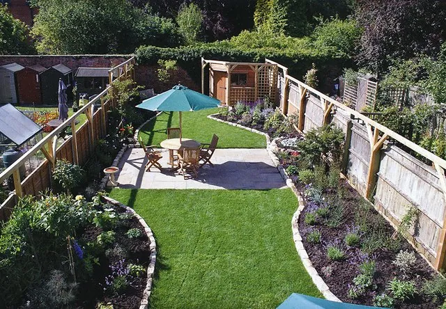 A town garden with a curved lawn, borders and a patio